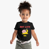 Child wearing a black t-shirt with a snail graphic and text on a white background