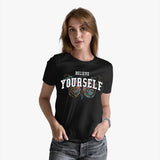 A woman wearing a black crew neck t-shirt with the text 'BELIEVE YOURSELF' on the front.