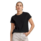 Woman wearing a black t-shirt and light-colored pants on a white background