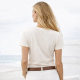Woman wearing a white t-shirt and white pants with a blurred background