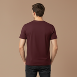Man wearing a maroon t-shirt on a brown background
