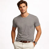 Man wearing a all day luxe modal t-shirt and white pants on a white background