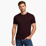 Man wearing a dark brown t-shirt and blue jeans on a white background
